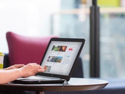 A student sitting at a table using Surreylearn on her laptop